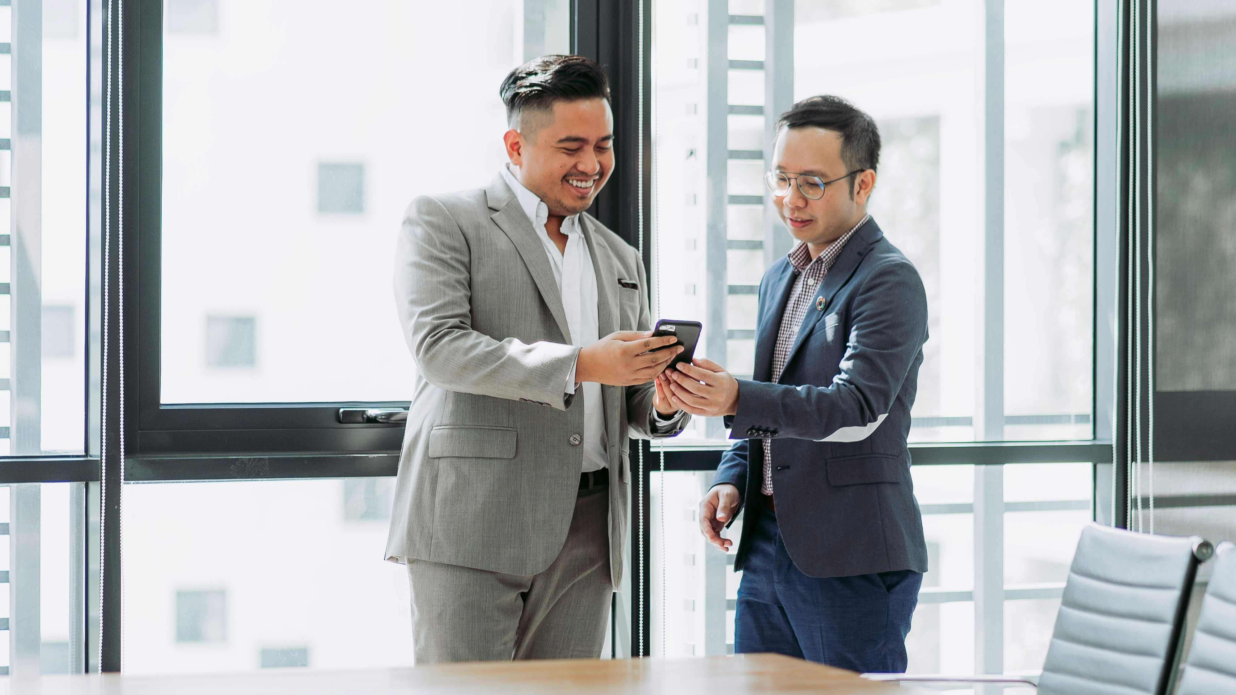 Man in Blue Long Sleeve Shirt Discussing with Man in White Long Sleeve Shirt